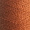 Nærbillede af Bæredygtig - økotex - bomuld nr 5714 - Orange spole med tæt viklede fibre, der skaber et tekstureret mønster. Subtil belysning fremhæver de rige farver og fine detaljer i denne miljøvenlige, økotex-certificerede bomuldsgarn.